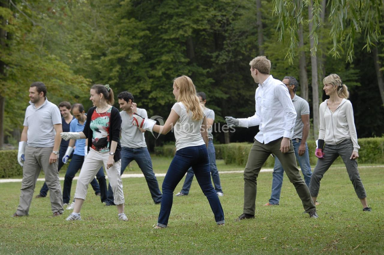 Un groupe de personnes pratique une activité physique en plein air dans un parc verdoyant.