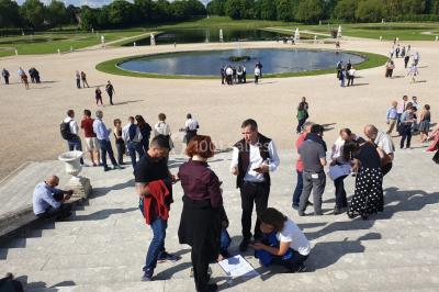 Un groupe de personnes souriantes pose dans une salle avec des rameurs et un écran projeté en arrière-plan.