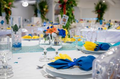 Table décorée avec des fleurs blanches, des ornements royaux ’Queen’ et ’King’, et un fond scintillant.