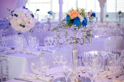 Table décorée avec des fleurs blanches, des ornements royaux ’Queen’ et ’King’, et un fond scintillant.