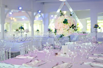 Table décorée avec des fleurs blanches, des ornements royaux ’Queen’ et ’King’, et un fond scintillant.