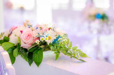 Table décorée avec des fleurs blanches, des ornements royaux ’Queen’ et ’King’, et un fond scintillant.