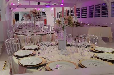 Table décorée avec des fleurs blanches, des ornements royaux ’Queen’ et ’King’, et un fond scintillant.