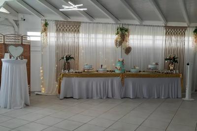 Table décorée avec des fleurs blanches, des ornements royaux ’Queen’ et ’King’, et un fond scintillant.