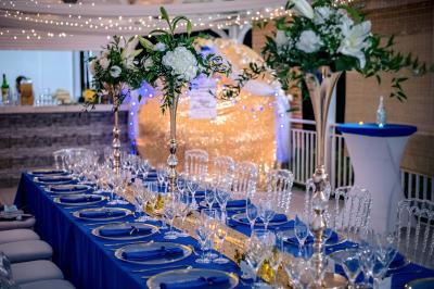 Table décorée avec des fleurs blanches, des ornements royaux ’Queen’ et ’King’, et un fond scintillant.