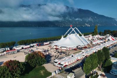 Miniature Location salle Aix-les-Bains (Savoie) - Chapiteaux Arlette Gruss - Aix-les-Bains #2 Foule faisant la queue devant un chapiteau illuminé au crépuscule, avec des montagnes en arrière-plan.