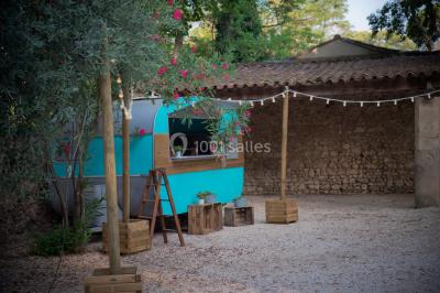 Façade d'une grande maison blanche entourée d'arbres, avec une pelouse verdoyante au premier plan.