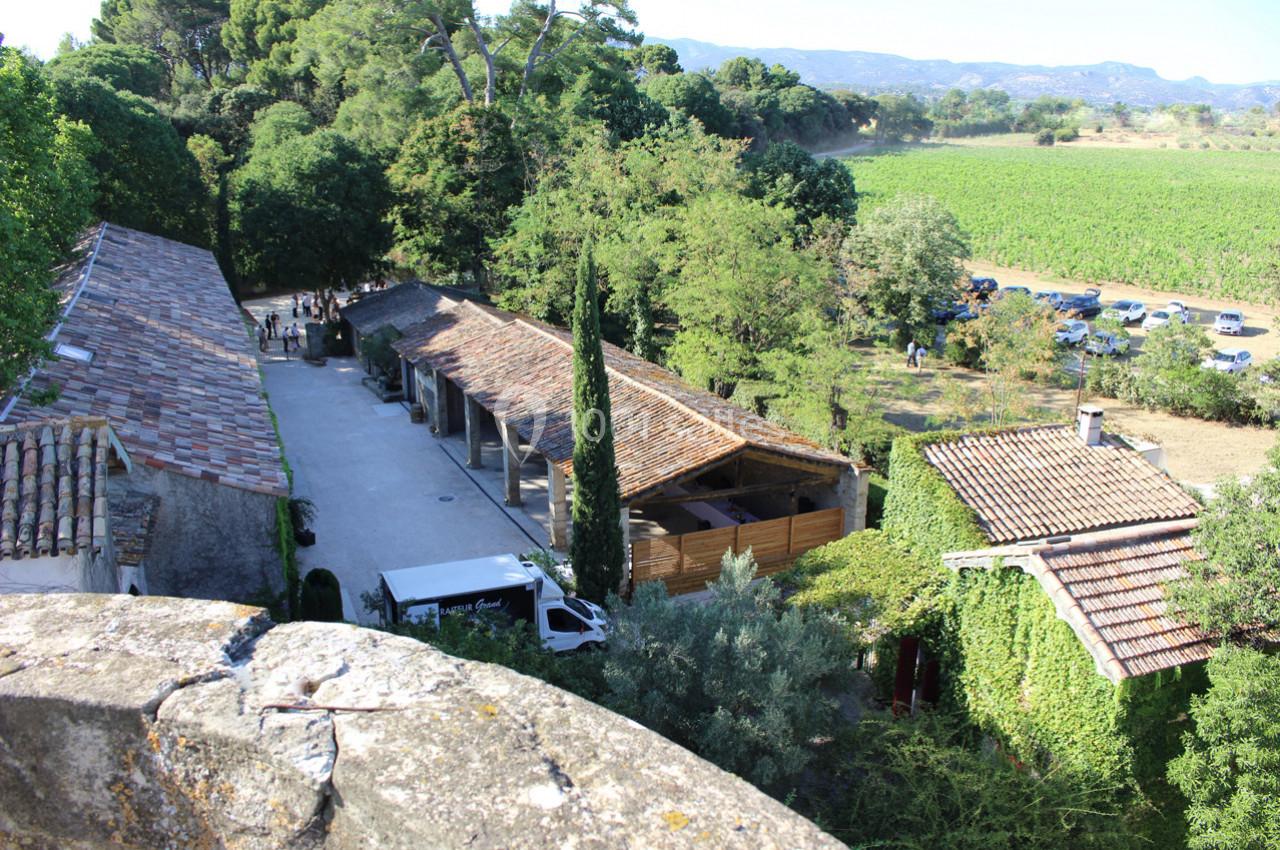 Vue aérienne d'un domaine rural avec bâtiments en pierre, cour centrale, vignes et végétation environnante.
