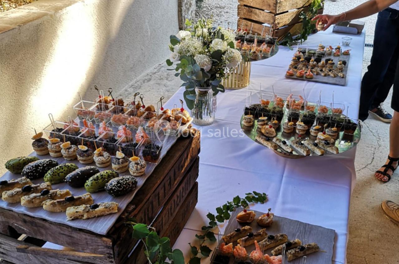 Buffet de pièces cocktail variées disposées sur une table avec décoration florale et caisses en bois.