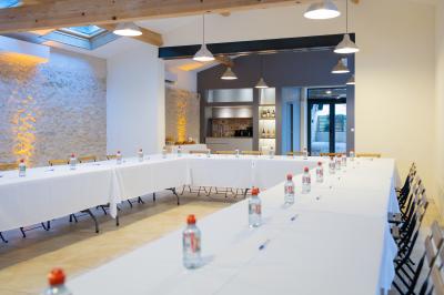 Façade d'une grande maison blanche entourée d'arbres, avec une pelouse verdoyante au premier plan.