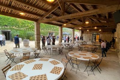Façade d'une grande maison blanche entourée d'arbres, avec une pelouse verdoyante au premier plan.