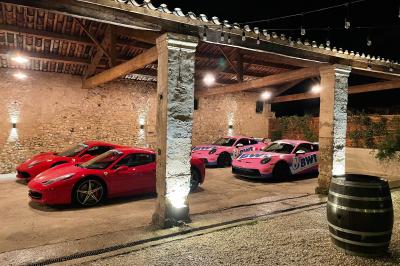 Façade d'une grande maison blanche entourée d'arbres, avec une pelouse verdoyante au premier plan.