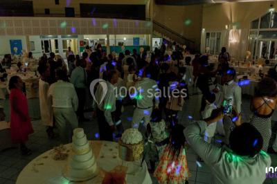 Miniature DJ Toulouse (Haute-Garonne) - Smiley Musik #4 Salle de réception avec tables dressées, nappes blanches, chaises décorées et éclairage naturel à travers de grandes…