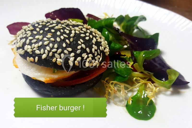 Traiteur Forest-sur-Marque (Nord) - Auberge du Tilleul #21 Burger au pain noir garni de poisson, tomate et salade, accompagné de jeunes pousses sur une assiette blanche.