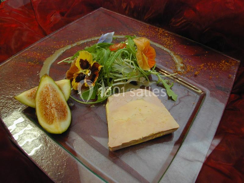 Traiteur Forest-sur-Marque (Nord) - Auberge du Tilleul #26 Assiette de foie gras accompagné de figues fraîches, salade verte et fleurs comestibles sur un fond rouge.