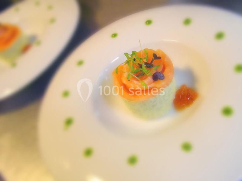 Entrée gastronomique composée de saumon fumé, mousse verte et garniture, présentée sur une assiette décorée.
