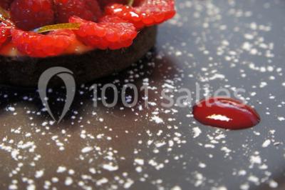 Miniature Traiteur Forest-sur-Marque (Nord) - Auberge du Tilleul #23 Dessert roulé recouvert de glaçage rouge, garni de rondelles de banane, avec des touches de coulis sur l'assiette blanche.