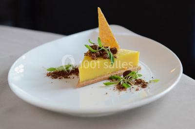 Miniature Traiteur Forest-sur-Marque (Nord) - Auberge du Tilleul #24 Dessert roulé recouvert de glaçage rouge, garni de rondelles de banane, avec des touches de coulis sur l'assiette blanche.