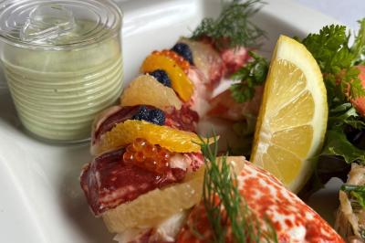 Miniature Traiteur Forest-sur-Marque (Nord) - Auberge du Tilleul #8 Dessert roulé recouvert de glaçage rouge, garni de rondelles de banane, avec des touches de coulis sur l'assiette blanche.