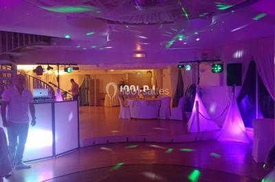 Miniature DJ Spézet (Finistère) - Anime dj Thony #11 Un couple danse sous des lumières violettes dans une salle sombre, vu depuis une table de mixage de DJ.