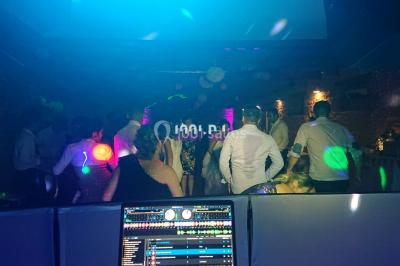 Miniature DJ Spézet (Finistère) - Anime dj Thony #6 Un couple danse sous des lumières violettes dans une salle sombre, vu depuis une table de mixage de DJ.