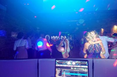 Miniature DJ Spézet (Finistère) - Anime dj Thony #3 Un couple danse sous des lumières violettes dans une salle sombre, vu depuis une table de mixage de DJ.