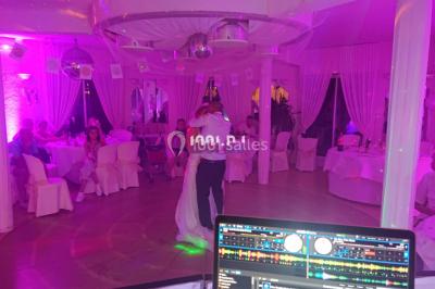 Miniature DJ Spézet (Finistère) - Anime dj Thony #13 Un couple danse sous des lumières violettes dans une salle sombre, vu depuis une table de mixage de DJ.