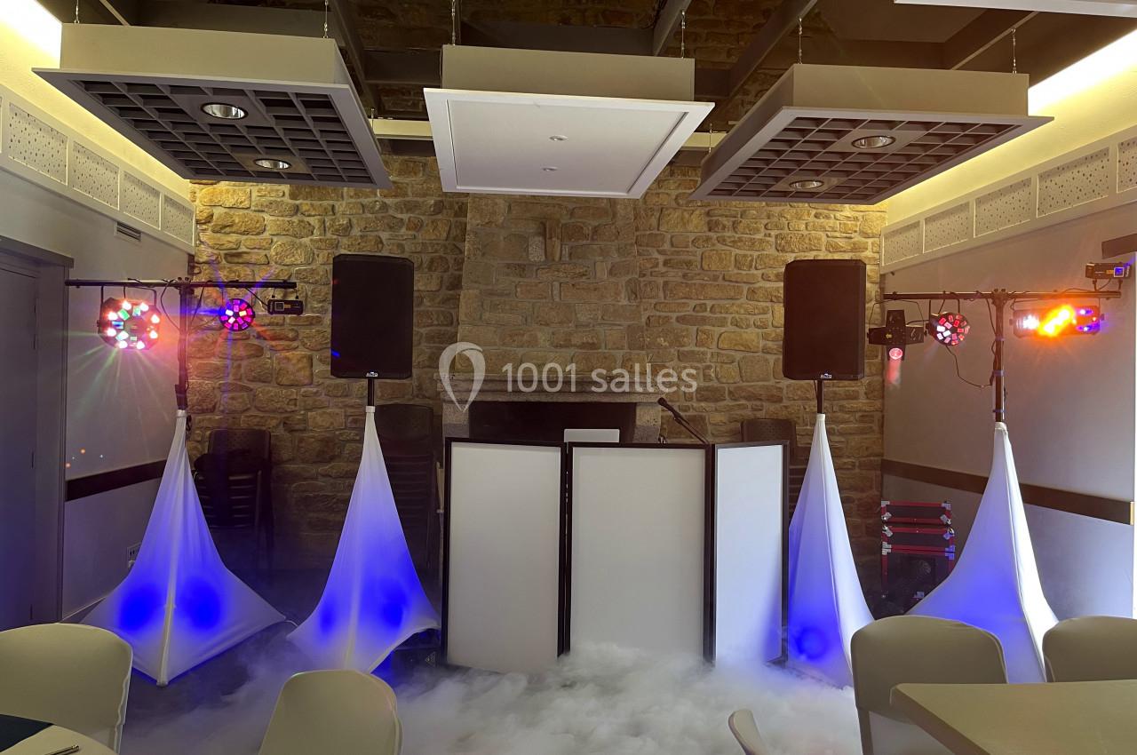 Installation de matériel de sonorisation et éclairage avec effets de fumée dans une salle en pierre.