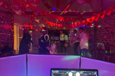 Miniature DJ Spézet (Finistère) - Anime dj Thony #18 Un couple danse sous des lumières violettes dans une salle sombre, vu depuis une table de mixage de DJ.