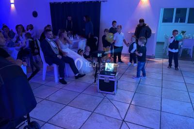 Miniature DJ Spézet (Finistère) - Anime dj Thony #20 Un couple danse sous des lumières violettes dans une salle sombre, vu depuis une table de mixage de DJ.