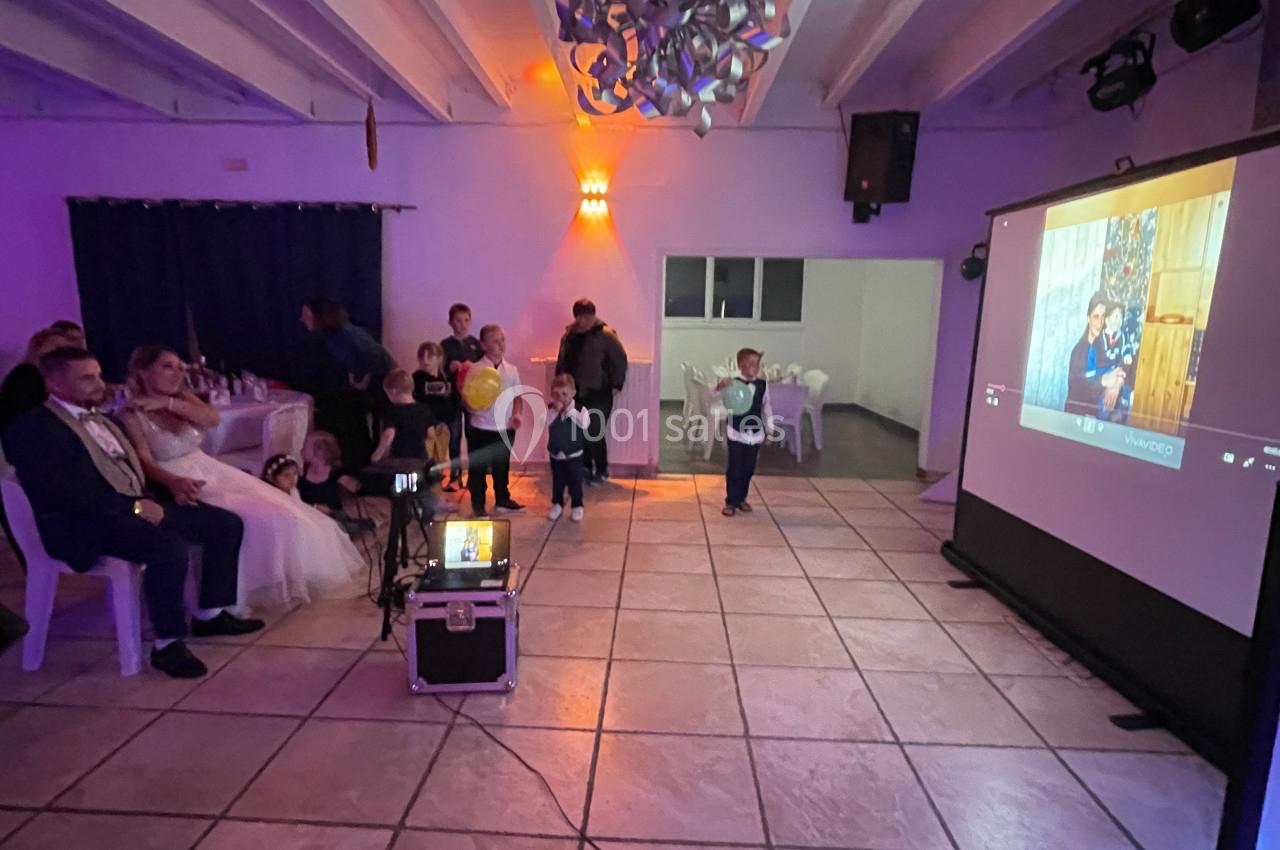 Un groupe de personnes assises et debout dans une salle, regardant une projection sur un écran.