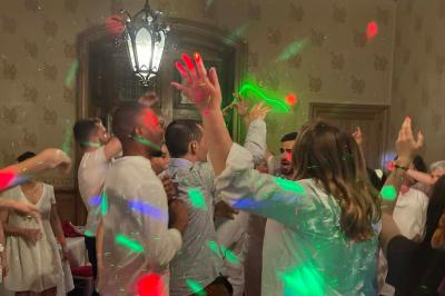 Miniature DJ Spézet (Finistère) - Anime dj Thony #31 Un couple danse sous des lumières violettes dans une salle sombre, vu depuis une table de mixage de DJ.