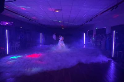 Miniature DJ Spézet (Finistère) - Anime dj Thony #32 Un couple danse sous des lumières violettes dans une salle sombre, vu depuis une table de mixage de DJ.