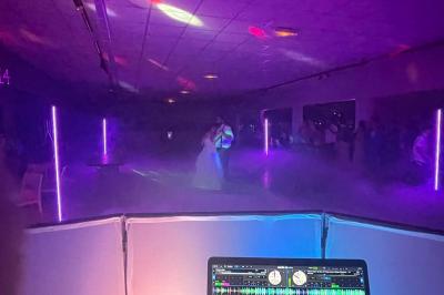 Miniature DJ Spézet (Finistère) - Anime dj Thony #35 Un couple danse sous des lumières violettes dans une salle sombre, vu depuis une table de mixage de DJ.