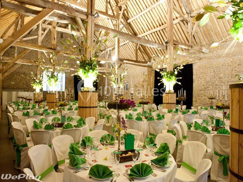 Location salle Ciney (Province de Namur) - Le Domaine d'Achêne #3 Salle de réception décorée avec des tables rondes, nappes blanches, serviettes vertes et arrangements floraux.