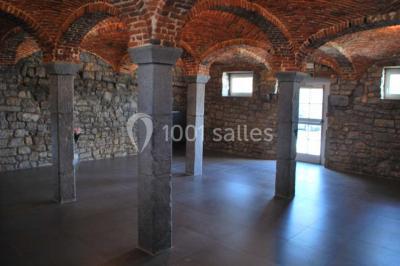 Miniature Location salle Ciney (Province de Namur) - Le Domaine d'Achêne #7 Voûtes en briques rouges soutenues par des colonnes en pierre dans une pièce au sol carrelé.