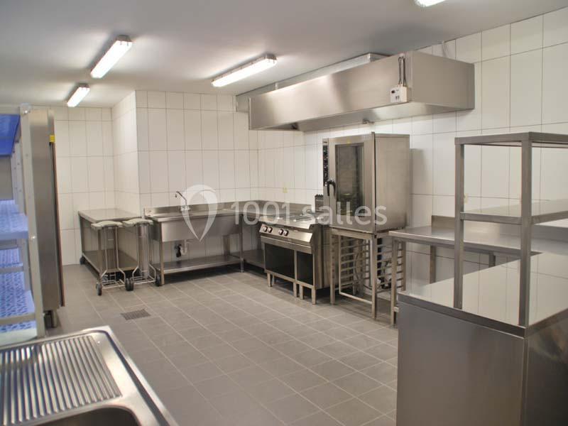 Location salle Ciney (Province de Namur) - Le Domaine d'Achêne #15 Cuisine professionnelle avec équipements en inox, comprenant four, plaques de cuisson, plans de travail et évier.