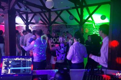 Miniature DJ Bourg-des-Comptes (Ille-et-Vilaine) - Animax 35 #3 Salle de réception décorée avec des tables rondes, nappes blanches, chaises ornées de nœuds beige et éclairage vert.