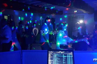 Miniature DJ Bourg-des-Comptes (Ille-et-Vilaine) - Animax 35 #6 Salle de réception décorée avec des tables rondes, nappes blanches, chaises ornées de nœuds beige et éclairage vert.