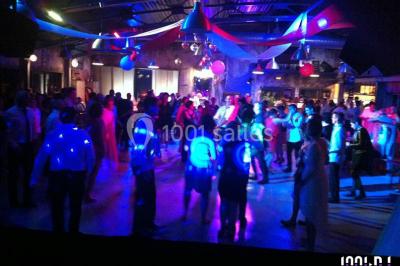 Miniature DJ Bourg-des-Comptes (Ille-et-Vilaine) - Animax 35 #14 Salle de réception décorée avec des tables rondes, nappes blanches, chaises ornées de nœuds beige et éclairage vert.