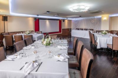 Salle de restaurant avec buffet circulaire, décorations lumineuses et grandes baies vitrées donnant sur un espace vert.