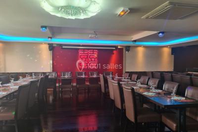 Salle de restaurant avec buffet circulaire, décorations lumineuses et grandes baies vitrées donnant sur un espace vert.
