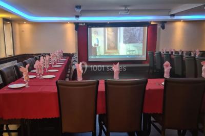 Salle de restaurant avec buffet circulaire, décorations lumineuses et grandes baies vitrées donnant sur un espace vert.