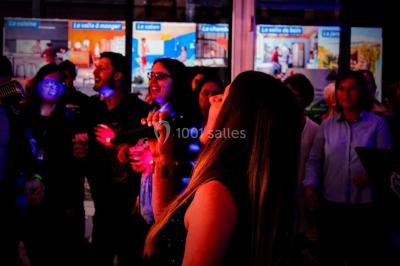 Flammes vives s'élevant d'un feu de bois sous une grille métallique, entourées de pierres sombres.