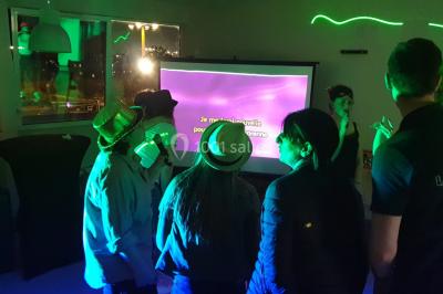 Flammes vives s'élevant d'un feu de bois sous une grille métallique, entourées de pierres sombres.