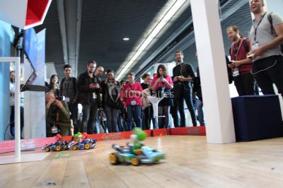 Flammes vives s'élevant d'un feu de bois sous une grille métallique, entourées de pierres sombres.