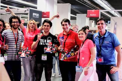 Flammes vives s'élevant d'un feu de bois sous une grille métallique, entourées de pierres sombres.