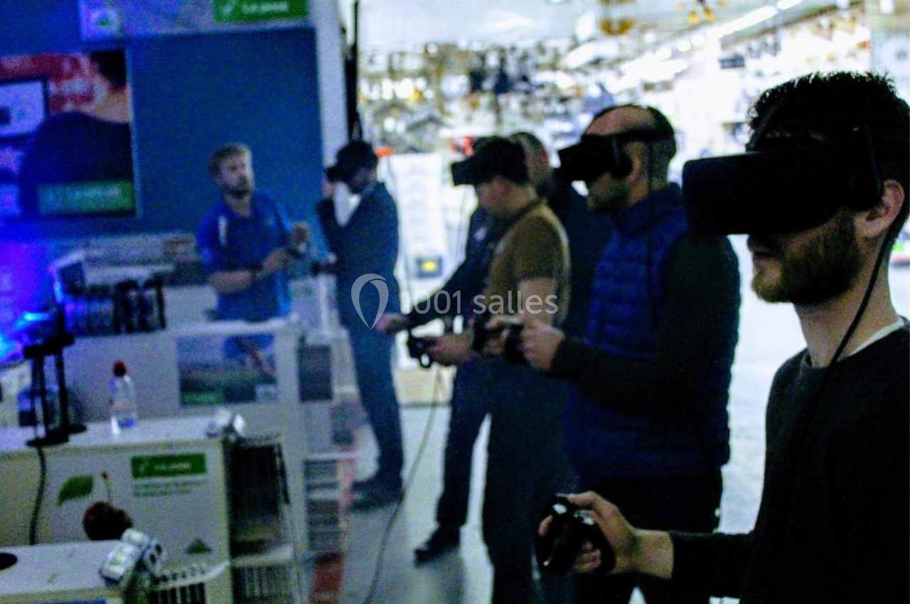 Des personnes utilisent des casques de réalité virtuelle et des manettes dans un espace intérieur lumineux.