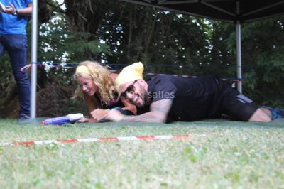 Flammes vives s'élevant d'un feu de bois sous une grille métallique, entourées de pierres sombres.