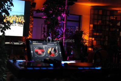 Flammes vives s'élevant d'un feu de bois sous une grille métallique, entourées de pierres sombres.